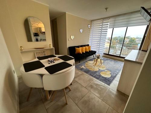 ein Wohnzimmer mit einem schwarz-weißen Tisch und Stühlen in der Unterkunft Alojamiento en linares in Linares