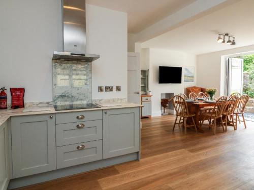 a kitchen and dining room with a table and chairs at Wendy's Cottage in Minehead