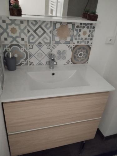 - un comptoir de cuisine avec un évier et un mur en carrelage dans l'établissement appartement 4/6 pers à 300 m de la plage, à Saint-Hilaire-de-Riez