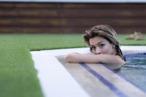 a woman laying in a swimming pool with her head on the water at Three Points Hotel in Beldibi
