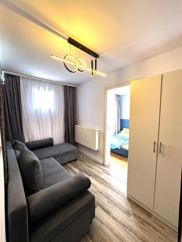 a living room with a couch and a bedroom at Azzur Studios Aparthotel in Constanţa