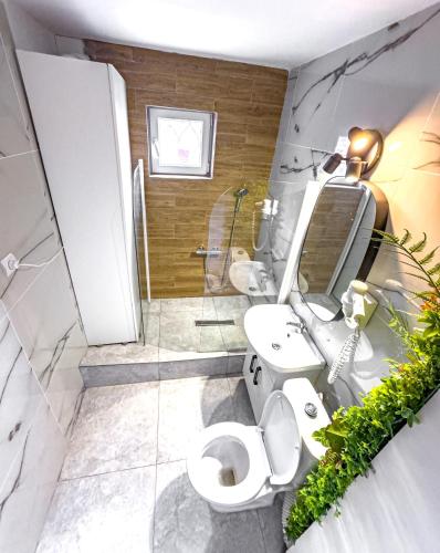 a bathroom with two sinks and a toilet and a shower at Azzur Studios Aparthotel in Constanţa