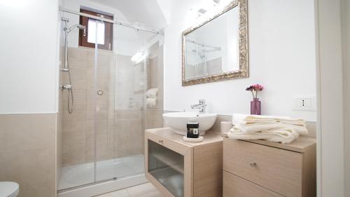 a white bathroom with a sink and a shower at La Casa Dei Nonni in Matera