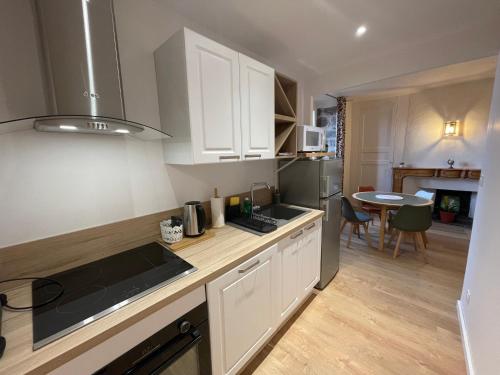 une cuisine avec des armoires blanches et un comptoir dans l'établissement Aux Portes du Mont Anis, au Puy-en-Velay