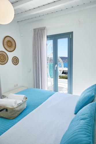 a bedroom with a bed with a view of the ocean at Sand Lily Villa Mykonos in Mýkonos City