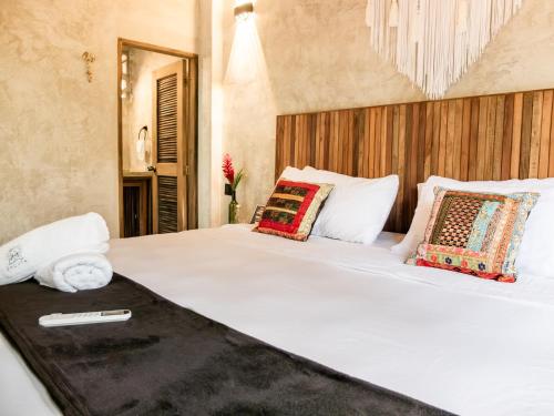 sypialnia z dużym białym łóżkiem z poduszkami w obiekcie Salvia Madre w mieście Santa Marta
