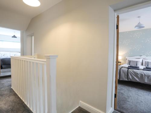 a bedroom with a bed and a hallway with a staircase at Ty Bara in Cemaes Bay