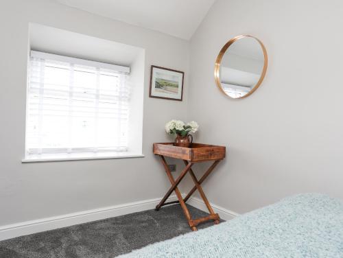 a bedroom with a mirror and a table with a bed at Ty Bara in Cemaes Bay