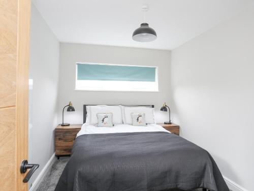 a bedroom with a bed with two pillows at Ty Bara in Cemaes Bay