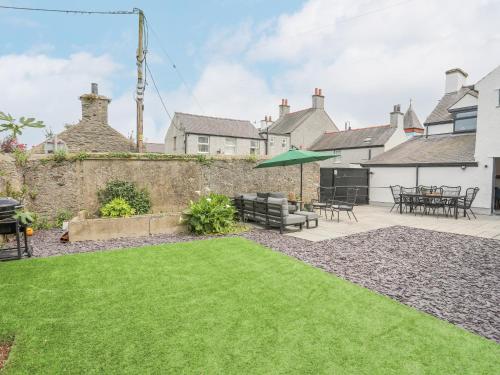a garden with a patio and a lawn at Ty Bara in Cemaes Bay