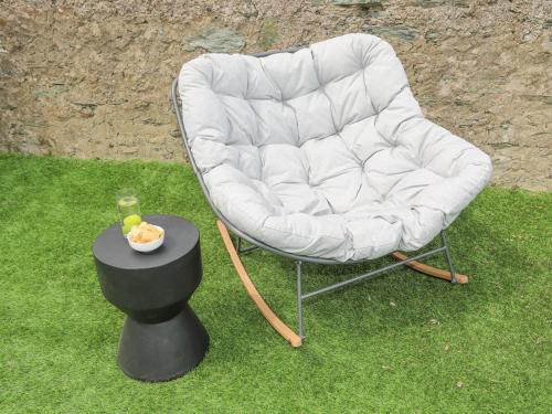 a white chair sitting on the grass next to a table at Ty Bara in Cemaes Bay