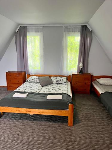 a bedroom with two beds and two windows at Wigierska Osada 2 in Danowskie