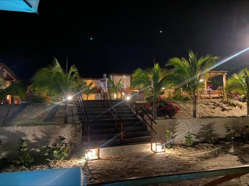 a man standing on the stairs at the beach at night at El Samay Hotel Boutique in Canoas De Punta Sal