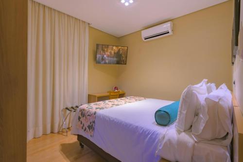a bedroom with a white bed and a window at Araçatuba Plaza Hotel in Araçatuba