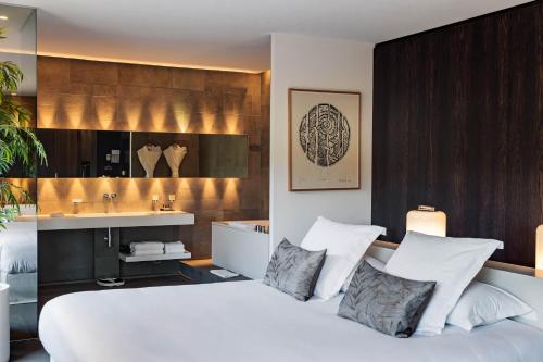 1 dormitorio con 1 cama blanca grande y lavamanos en Bdesign & Spa, en Paradou