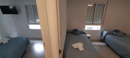 a room with two beds in a room with windows at La Huella del Peregrino - Ionut Preda in Palas de Rei 