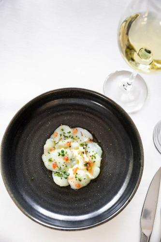 a black plate with dumplings on a table at Bdesign & Spa in Paradou