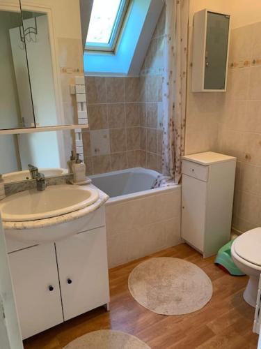 une salle de bain avec un lavabo, une baignoire et des toilettes dans l'établissement Charmante maison de campagne avec piscine, à Saint-Julien-aux-Bois