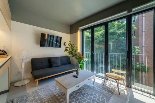 a living room with a blue couch and large windows at Encantador espacio cercano de Barrio Italia in Santiago
