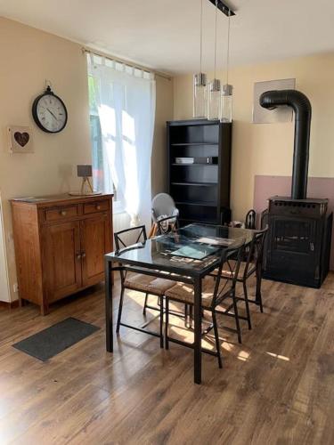 - une salle à manger avec une table et un poêle à bois dans l'établissement Charmante maison de campagne avec piscine, à Saint-Julien-aux-Bois