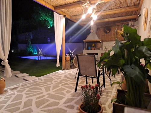 um quarto com uma cadeira e um palco com uma mesa em Natural House with Pool & private parking em Heraclião