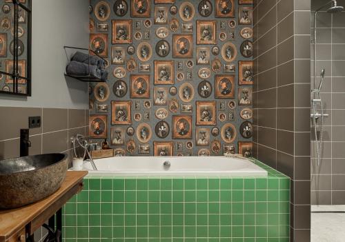 a bathroom with a bath tub and a tile wall at Hrísdalur stable villa in Vegamót