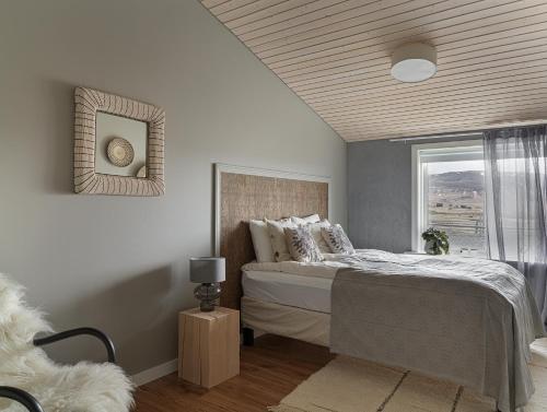 a bedroom with a large bed and a window at Hrísdalur stable villa in Vegamót