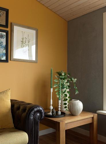 a living room with a couch and a table with plants at Hrísdalur stable villa in Vegamót