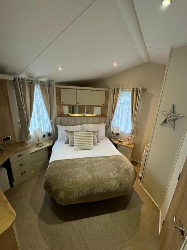 a bedroom with a large bed in a room at Golden Anchor - The Vogue - Coastal Caravan Breaks in Chapel Saint Leonards