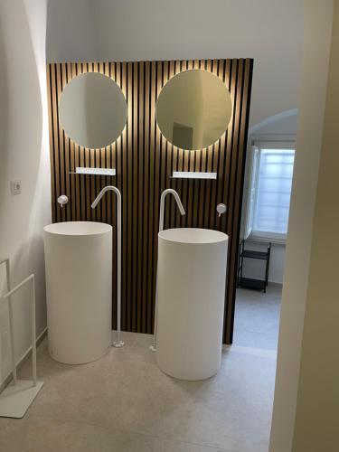 a bathroom with two sinks and two mirrors at Giardini di Luce in Matera