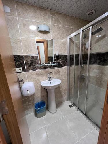 a bathroom with a sink and a shower at Uzungöl Kuzey Park Pansiyon in Uzungöl