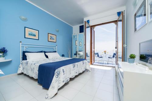 ein blaues Schlafzimmer mit einem Bett und einem Balkon in der Unterkunft Casa Jole in Amalfi