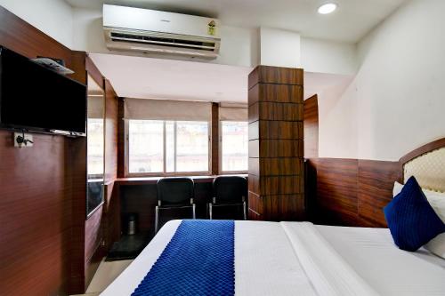 a hotel room with a bed and a flat screen tv at Hotel Q Inn in Kolkata