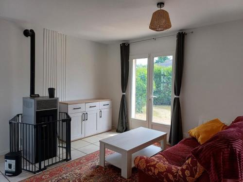 un salon avec un canapé et une table dans l'établissement Charmante chambre de hôte en compagne avec jardin, à Souppes-sur-Loing