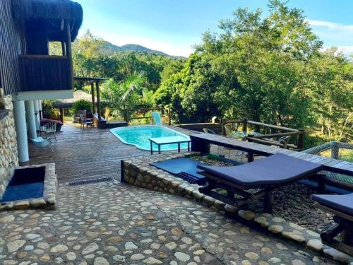 einen Pool mit einem Picknicktisch und einer Bank in der Unterkunft Vila Koh Phi Phi in Iporanga