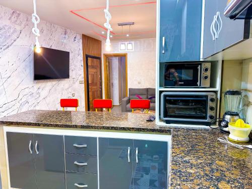 a kitchen with a counter with a microwave and a stove at VELUXA - LUXURY HOLIDAY HOMES - Centric flat in Tangier