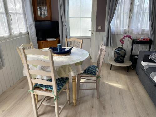 - un salon avec une table et des chaises dans l'établissement Mobil home Cristal, à Biville-sur-Mer
