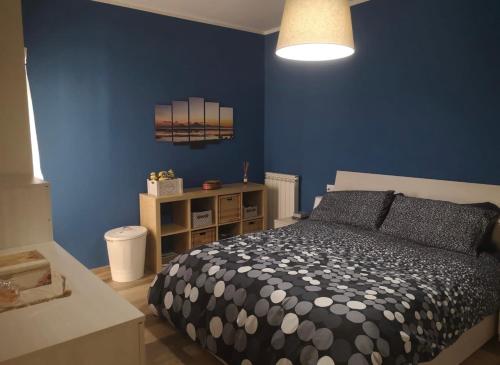 Un dormitorio con una cama y una pared azul. en Casa Camilla, en Grosseto