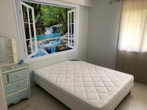 une chambre avec un lit et une cascade à l'extérieur d'une fenêtre dans l'établissement Magnifique Bas de villa entièrement indépendant, à Cannes