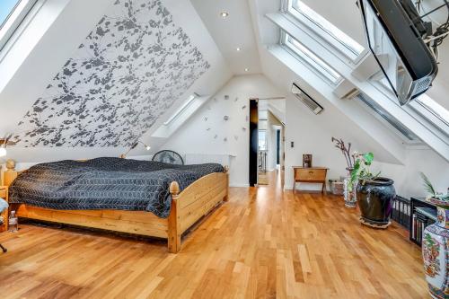 a bedroom with a large bed in a room with skylights at Nedlagt Landbrug med 3 lejligheder in Vejle