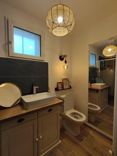 une salle de bain avec toilettes, lavabo et miroir dans l'établissement La Maisonnette - Disneyland Paris, à Chanteloup-en-Brie