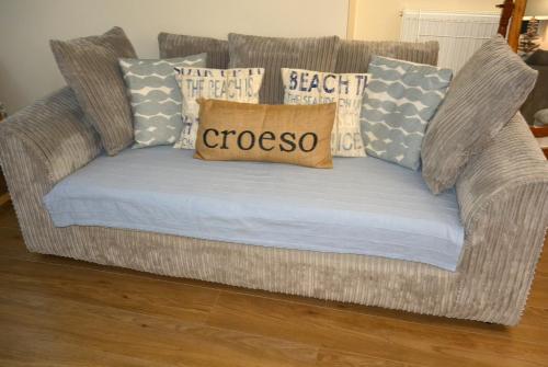 a couch with pillows on it in a living room at Superb Cintra Beachside Apartments in Llandudno