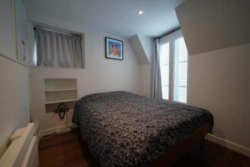 a small bedroom with a bed and a window at Appartement de Paul in Aurillac