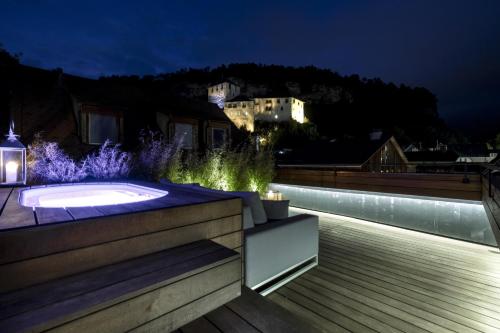 a garden with a hot tub at night at Gutwinski Hotel in Feldkirch