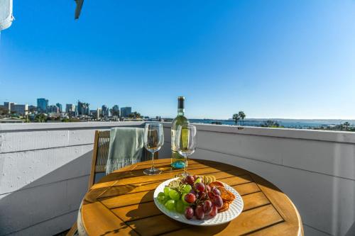 a table with a plate of fruit and wine glasses at Bankers Hill Hideaway with AC Views and Parking in San Diego