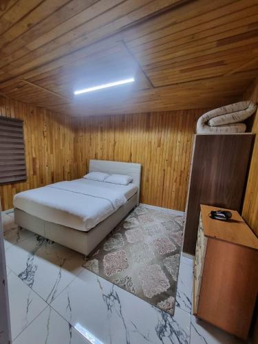 een slaapkamer met een bed in een houten kamer bij Özkan Apart in Çaykara