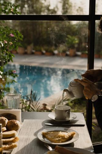 a person is pouring coffee into a cup on a table at Dar Tanja Boutique Hotel in Tangier