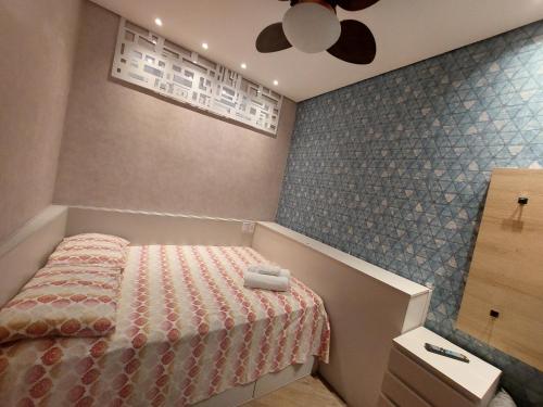 a bedroom with a bed and a ceiling fan at Book Santos - Unlimited 1608 Panorâmico c/ 3 dorm in Santos