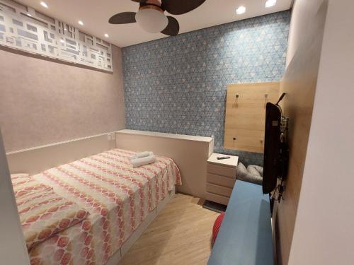 a bedroom with a bed and a blue tiled wall at Book Santos - Unlimited 1608 Panorâmico c/ 3 dorm in Santos