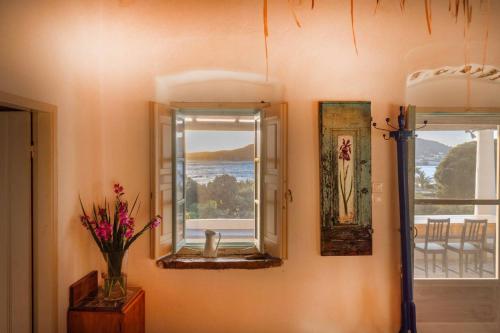 a room with a mirror and a vase of flowers on a wall at Annas Katikia in Drymonas